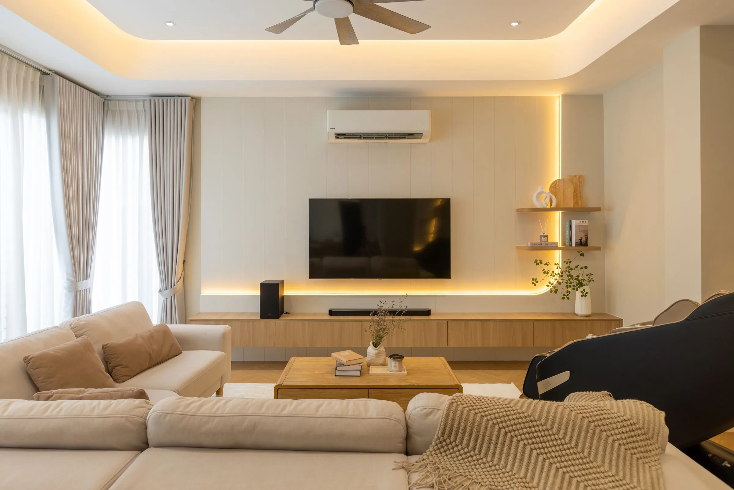 Living room with a backlit TV feature wall and built-in media cabinetry — Cabinet Studio