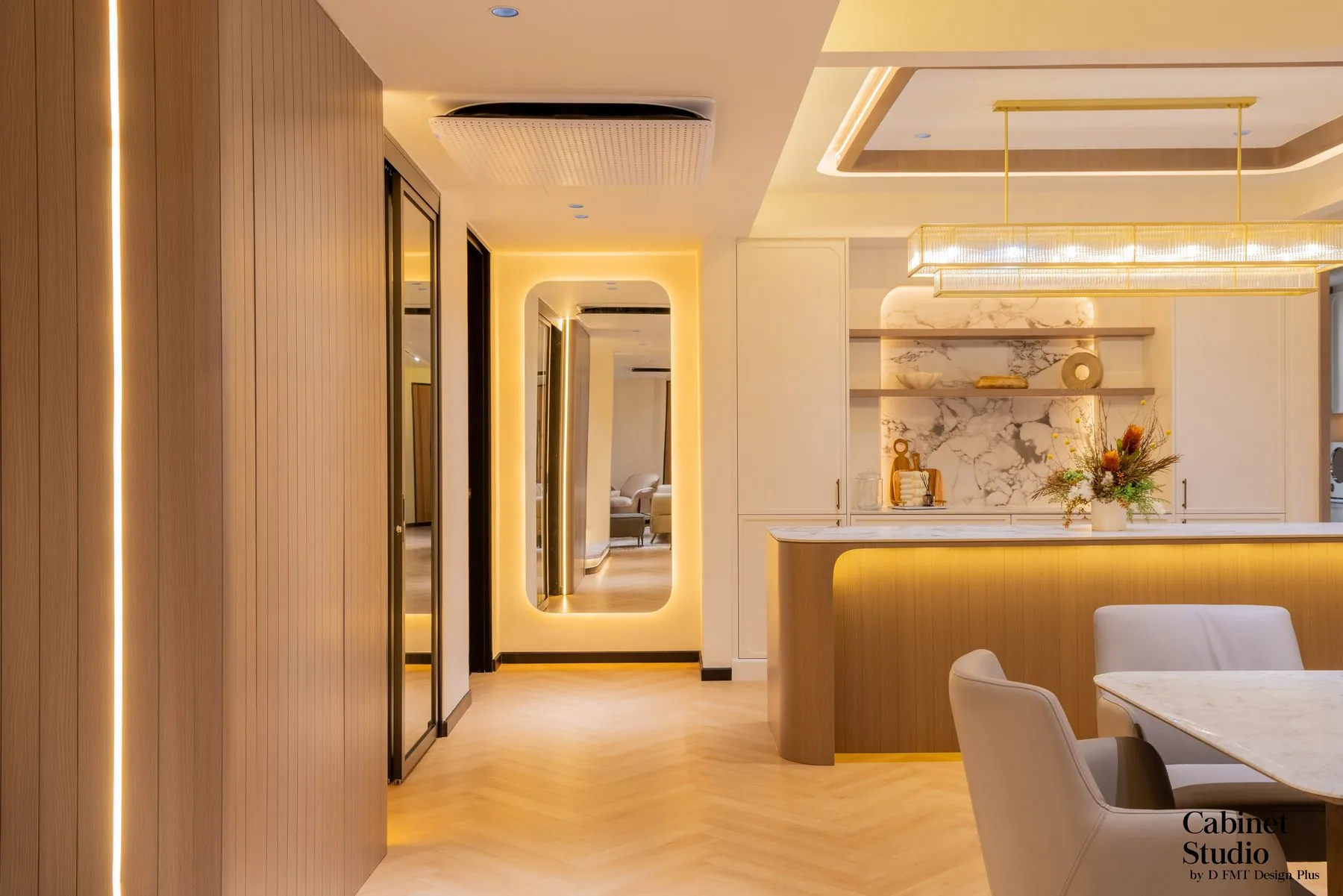Hallway with an arched mirror leading to a marble-look kitchen island — Cabinet Studio