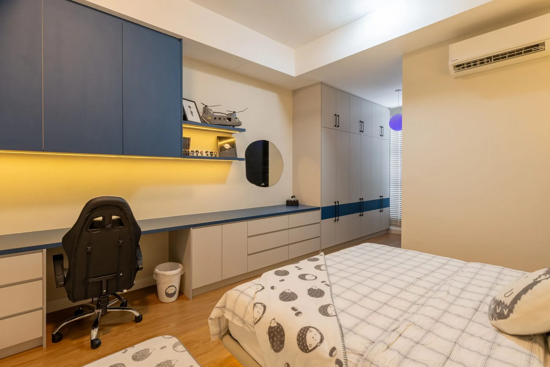 Bedroom study with navy overhead cabinets, a long desk and shelving — Cabinet Studio